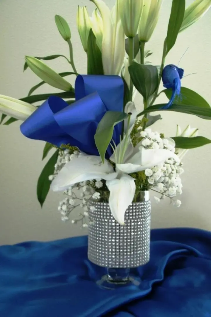 Mother's Day arrangement, featuring White hibiscus in a glass vase with blue ribbon. Mother's Day arrangement, featuring White hibiscus in a glass vase with blue ribbon.