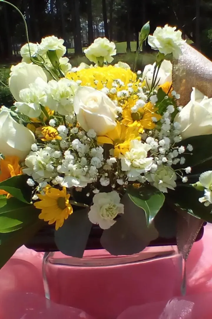 Mother's Day floral arrangement featuring white roses, white carnations and yellow daisies. Mother's Day floral arrangement featuring white roses, white carnations and yellow daisies.