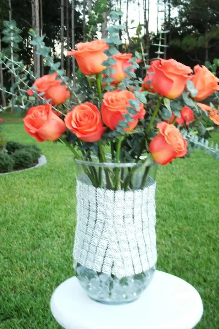 Mother's Day Floral arrangement featuring orange long-stem roses in a glass vase. Mother's Day Floral arrangement featuring orange long-stem roses in a glass vase.