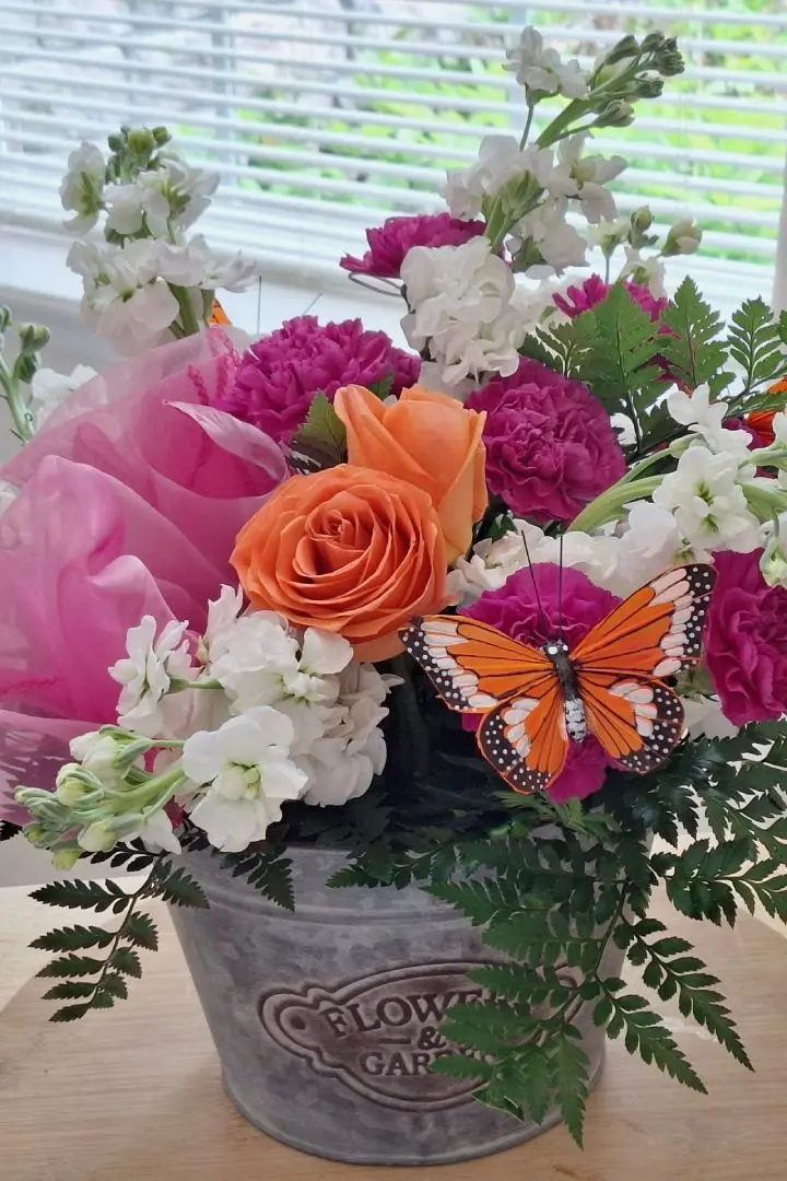 Mothers Day floral arrangement featuring pink carnation and pink carnations with butterfly decoration, designed by Lorraine for Mothers Day in Oakleaf Plantation, FL Mothers Day floral arrangement featuring pink carnation and pink carnations with butterfly decoration, designed by Lorraine for Mothers Day in Oakleaf Plantation, FL