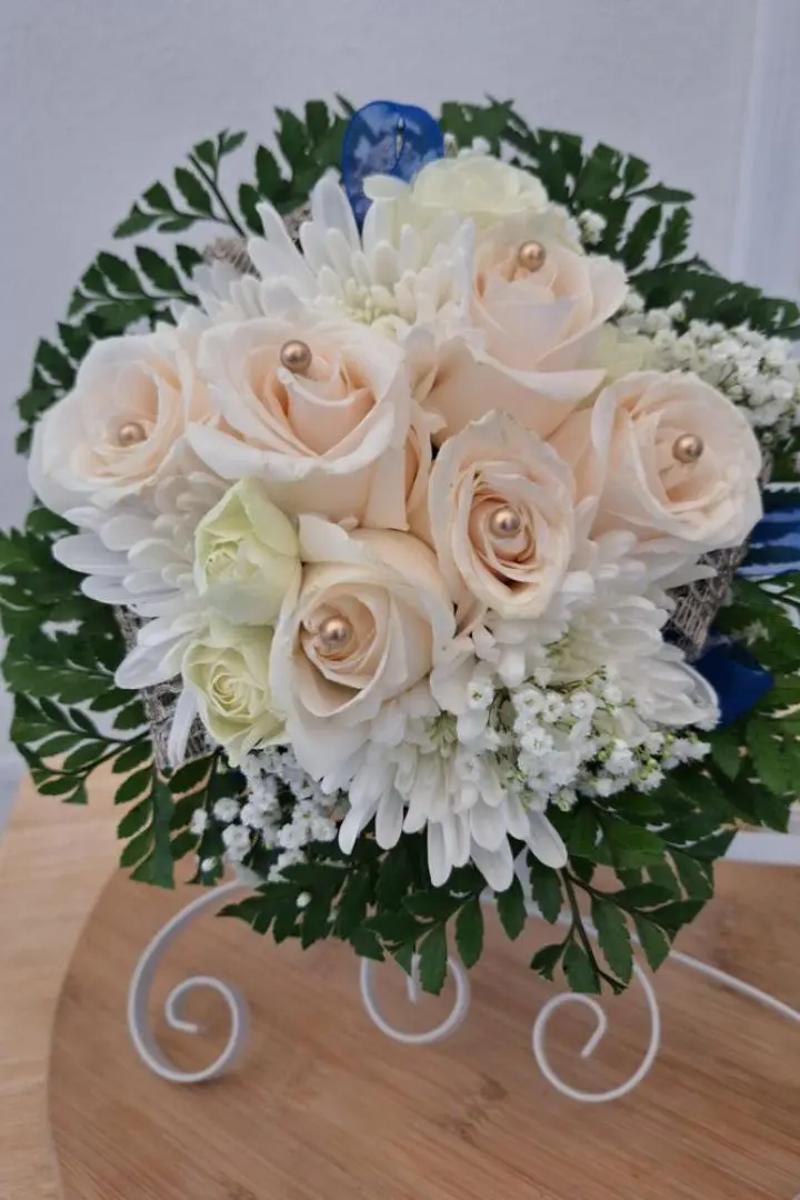 A custom wedding bridal bouquet with pink roses and white flowers with blue ribbon, designed by Lorraine for a wedding in Naval Air Station Jacksonville, FL.